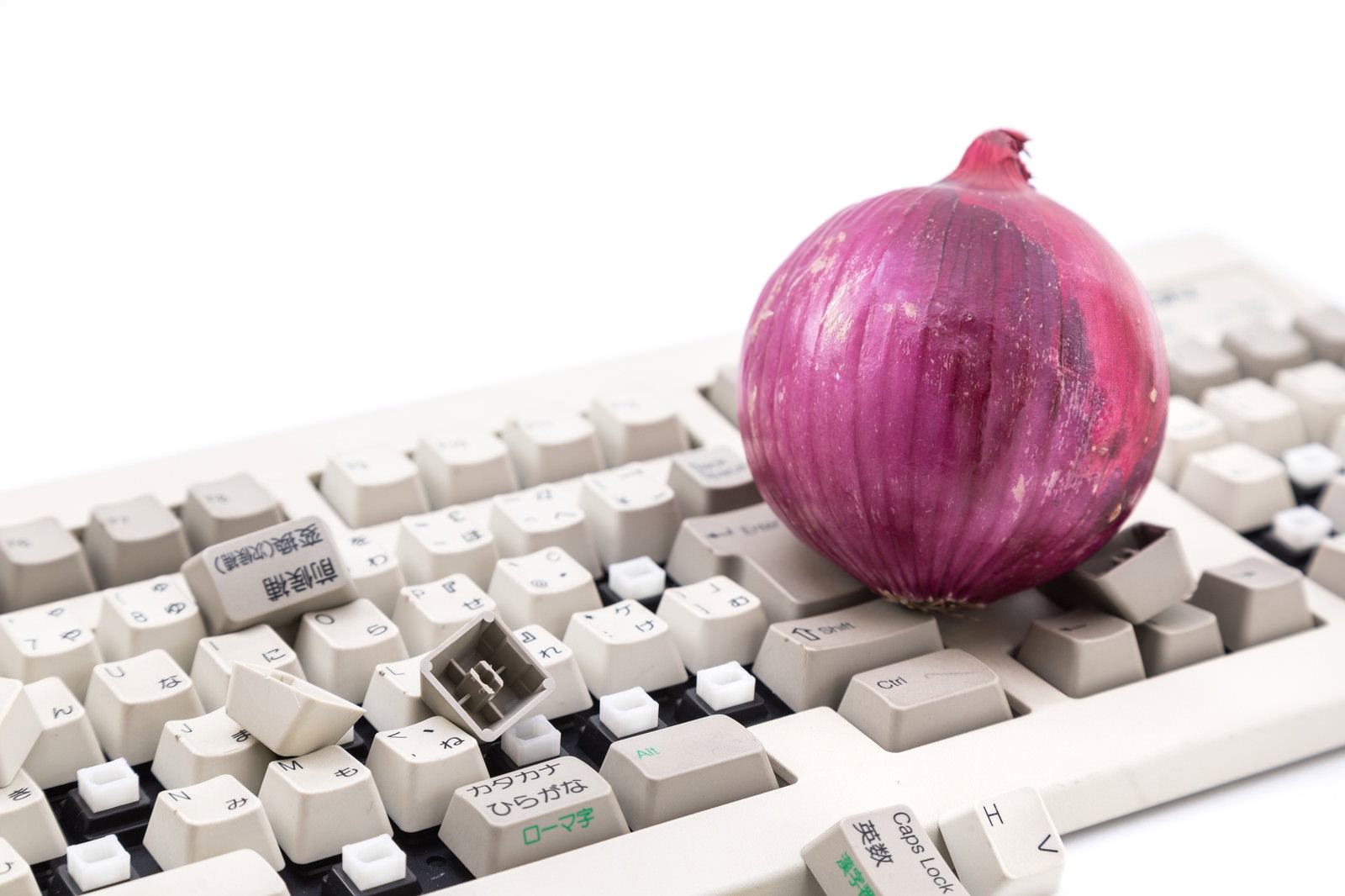 白いキーボードの上に置かれた紫玉葱