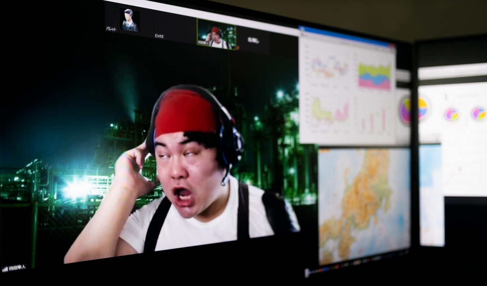 赤いキャップを被った男性がリモート会議中に焦った表情で白目を向いている［モデル：段田隼人］