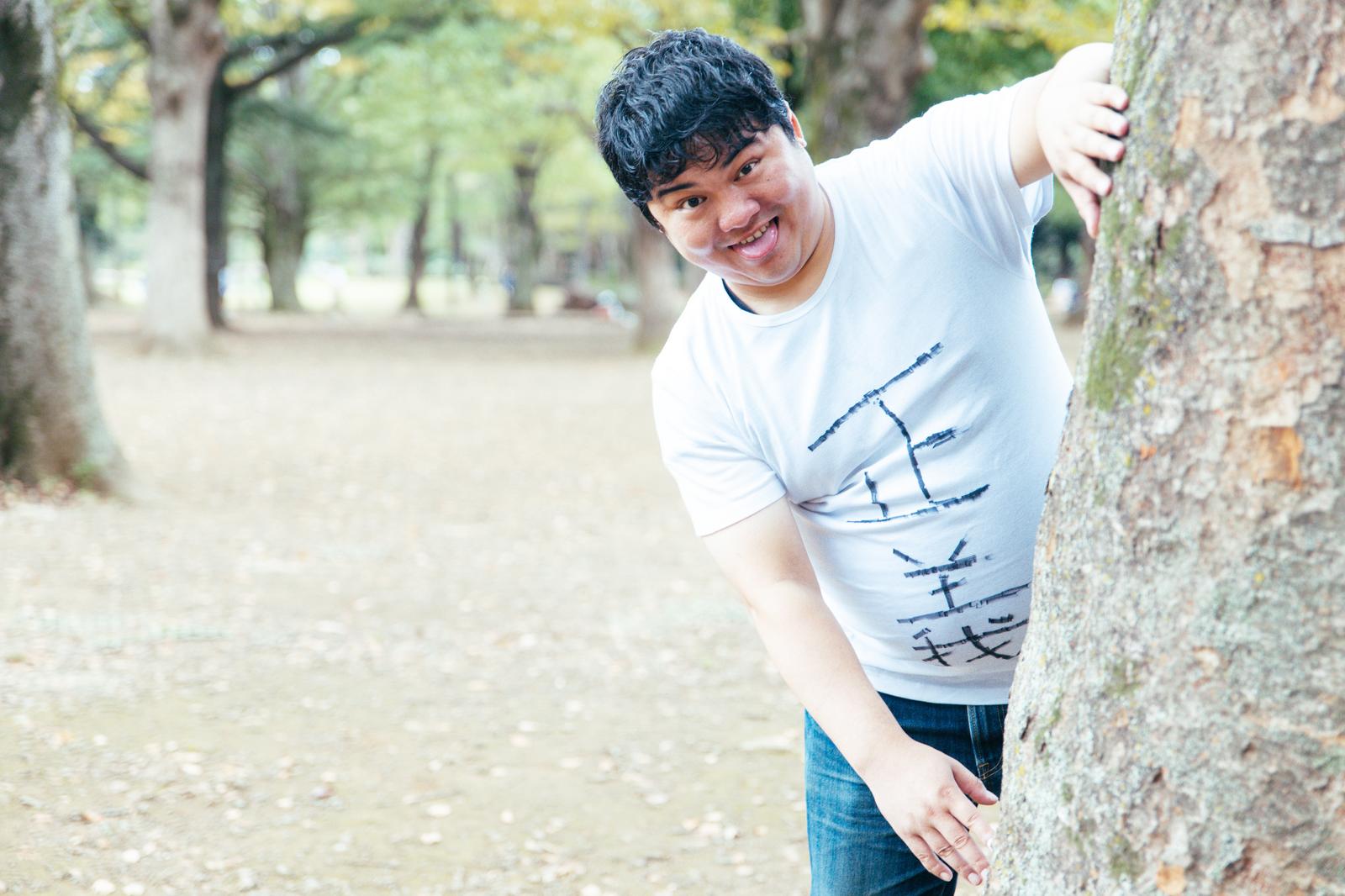 スマートフォンを持ちながらメモを取るスーツ姿のビジネスマン［モデル：段田隼人］