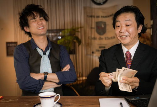 貸そう通貨で現金を数える男性と交渉する会社員