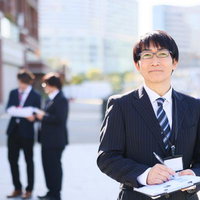 風通しのよい職場で資料を手にするビジネスマンの写真