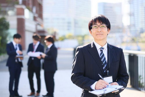 風通しのよい職場で資料を手にするビジネスマン