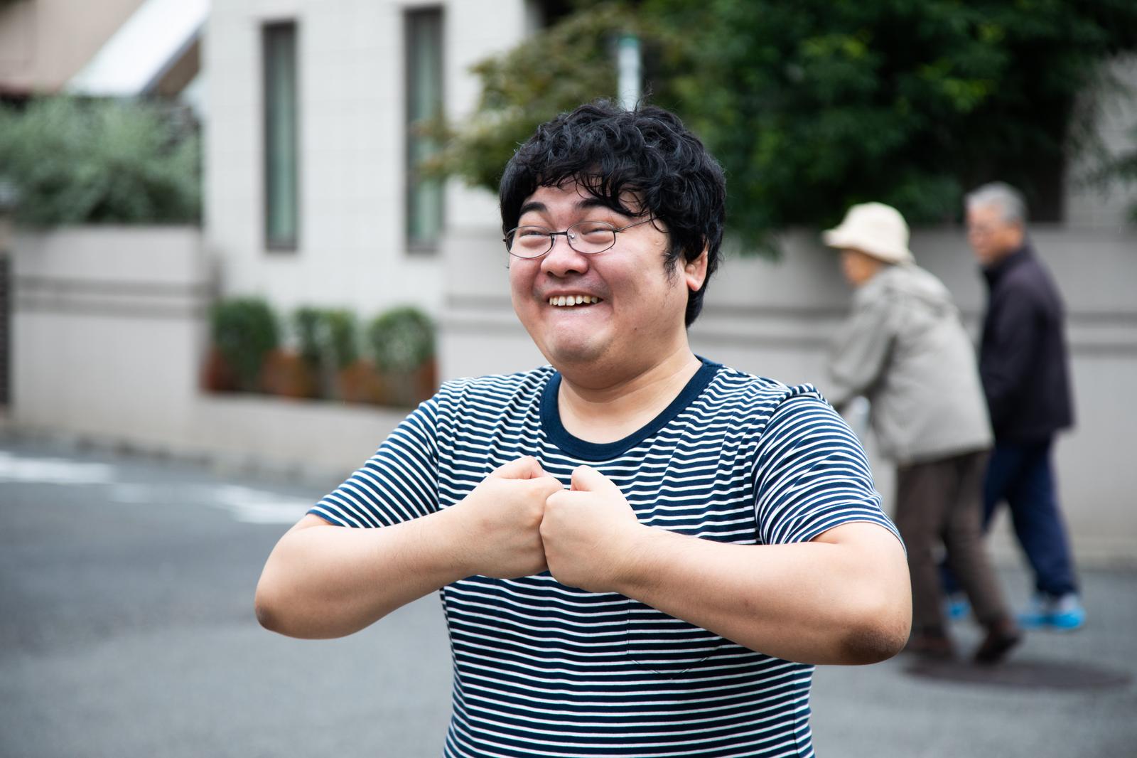 階段に座って青いコーンを被った人物の写真［モデル：段田隼人］