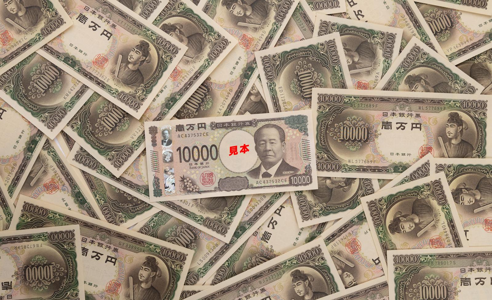 新旧の一万円札が複数枚、重なるように並べられた状態