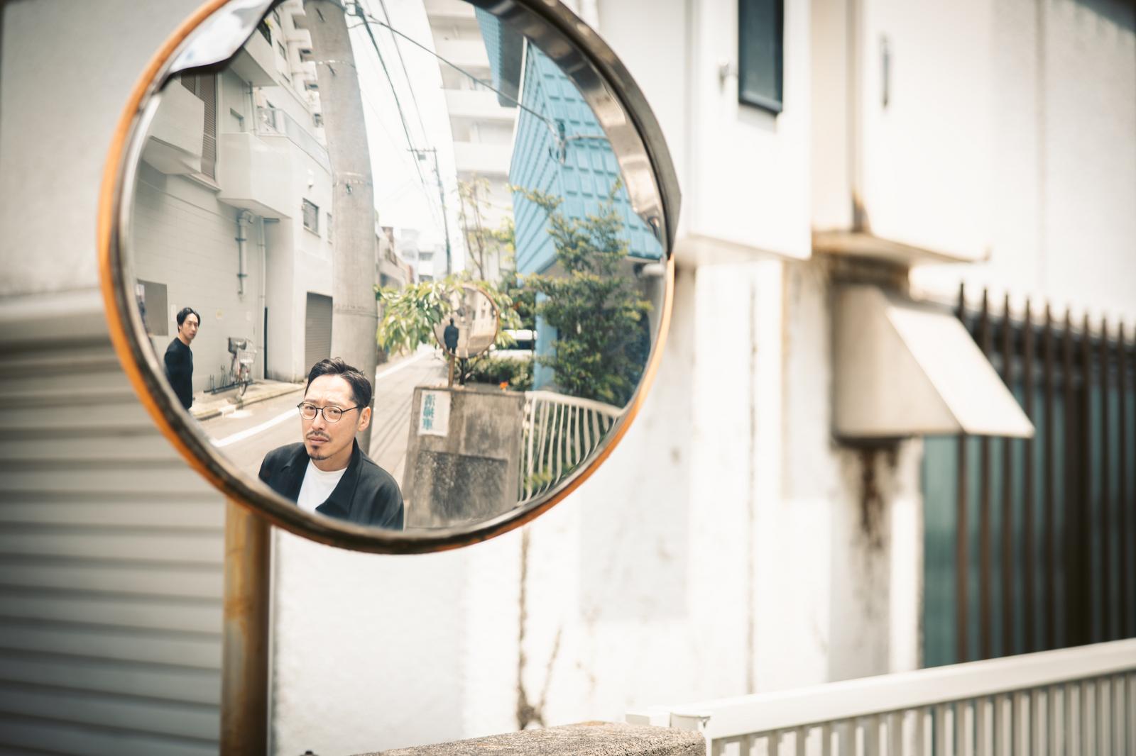 会議室でスマートフォンを見せながら説明する上司と男性社員［モデル：ゆうせい 大川竜弥］