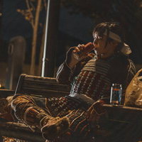 武者終業 夜の公園でやけ酒をする甲冑姿の男性の写真