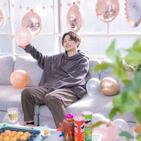 推し活パーティーで風船を掲げて喜ぶ男性の写真