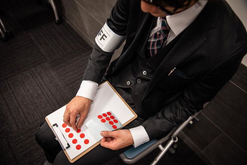 決勝戦のフォーメーションをシールで案内する男性