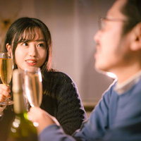 ほんとに一杯だけだからね、とシャンパンで乾杯するカップルの写真