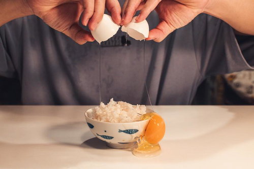 卵の殻が割れて生卵がたれるたまご欠けごはん