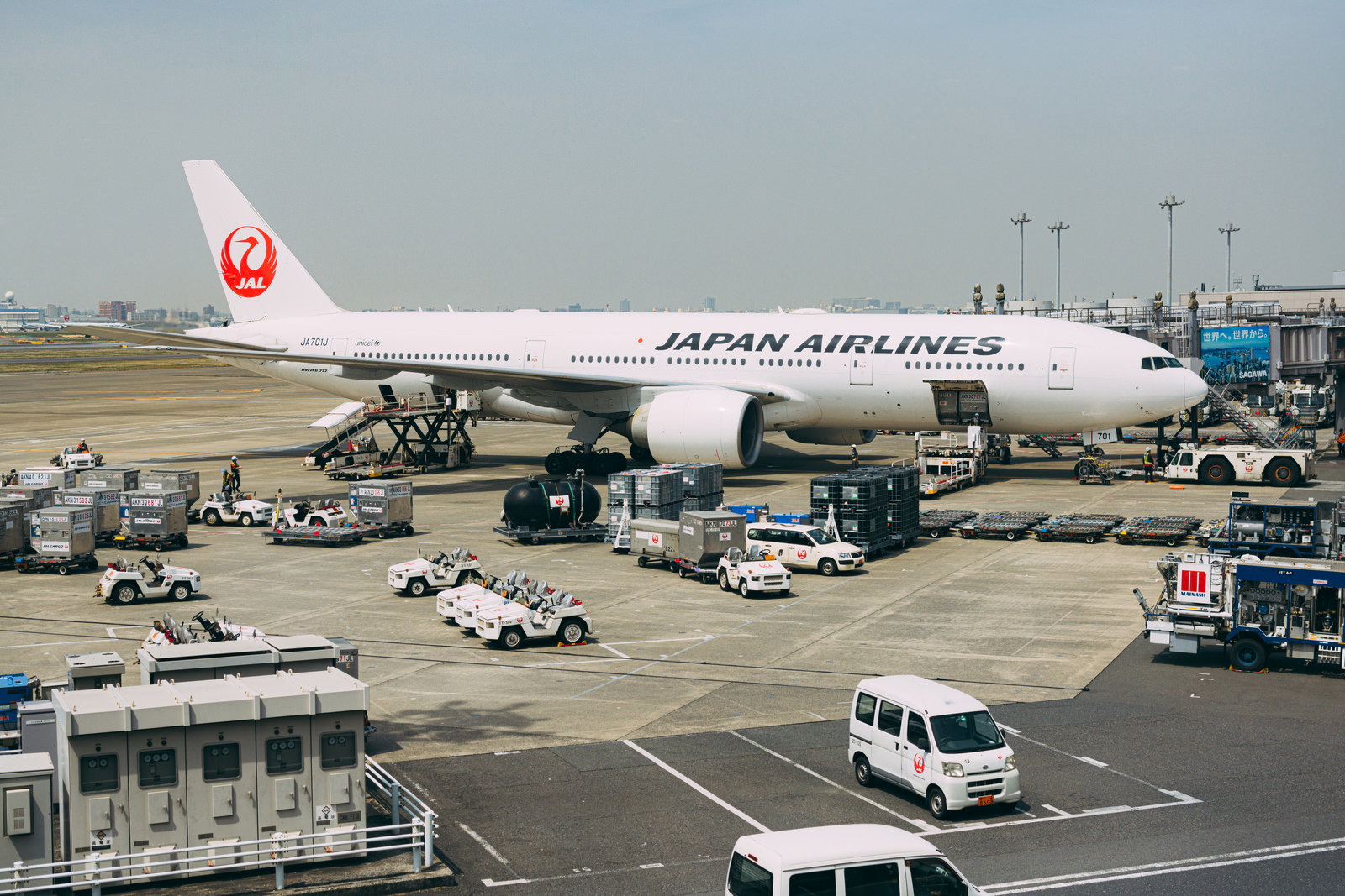 空港の滑走路に駐機している白い機体の日本航空旅客機