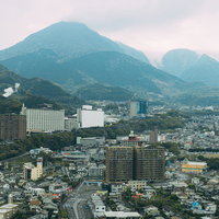 別府国際コンベンションセンター最上階から撮影したグローバルタワーと温泉街の夕景の写真