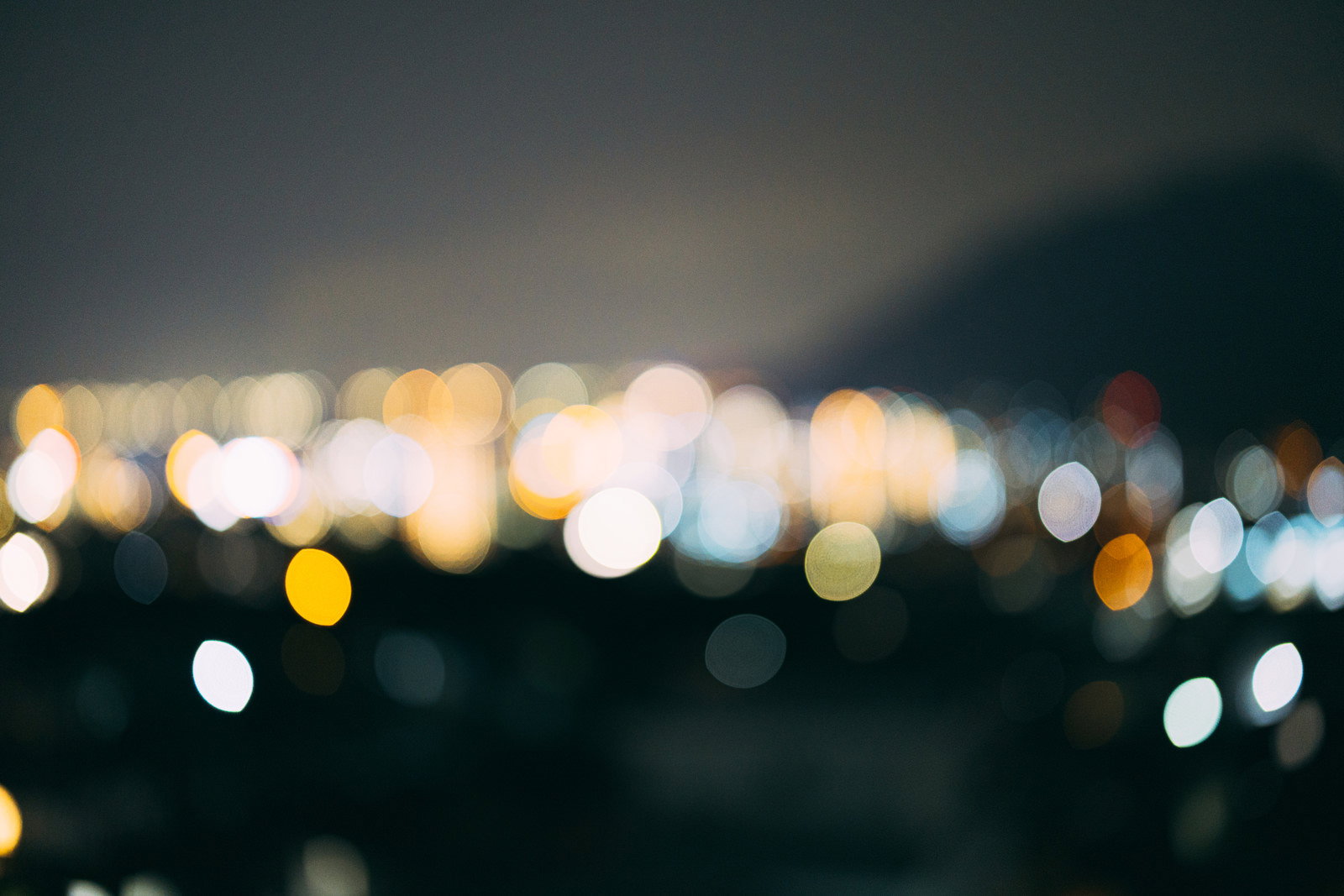 街の光がぼかされて丸い光の粒となった夜景の玉ボケ