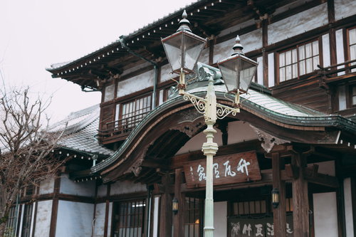 別府・竹瓦温泉前に立つ昭和レトロな街灯と温泉街の夜景