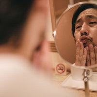 恋人に「キス顔がキモい」と言われ鏡を見て落ち込む男性の写真