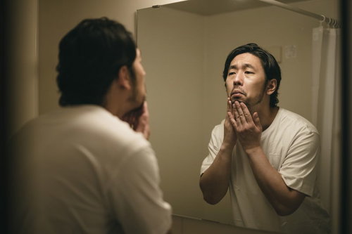 髭の脱毛をしようか悩む洗面所の男性のモーニングルーティーン