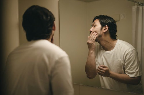 昨日の試合で殴られたあごが痛む無精髭の男性ボクサー