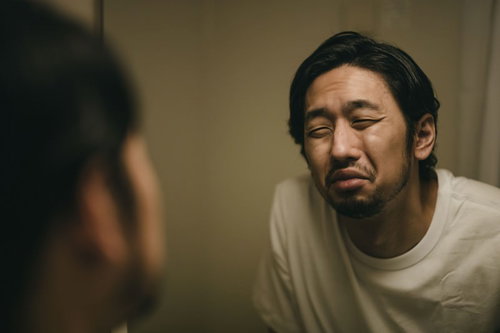 徹夜で月曜日を迎える無精髭の男性の疲労した表情