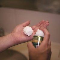 手の平に乗せたシェービング用の泡とクリームの写真