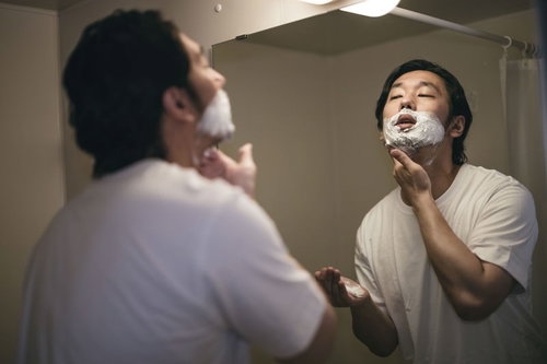 剃刀負けしないように念入りにシェービングクリームで泡タイムを過ごす男性