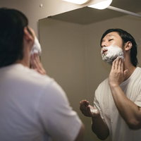 首元まで念入りにシェービング剤を塗る男性の写真