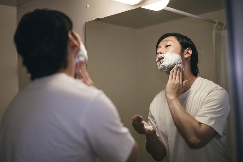 首元まで念入りにシェービング剤を塗る男性