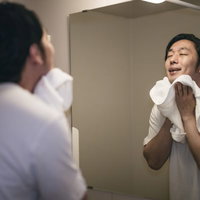 洗顔後のさっぱり感に浸る男性のバスルームの写真
