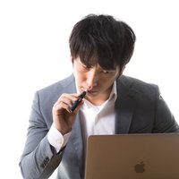 ネットの事件を追うIT刑事がデスクで電子タバコを吸うの写真