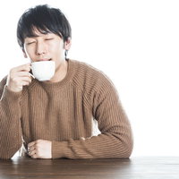 温かい紅茶を飲んで幸せそうな男性のポートレートの写真