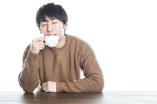 温かい紅茶を飲んで幸せそうな男性のポートレート