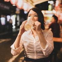 居酒屋でひとり呑み、チューハイをグビグビ飲む女性の写真