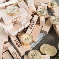 崩れ落ちたジェンガと散らばるビットコインの写真