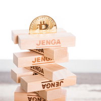 ぐらつくジェンガの上に乗る不安定なビットコインの写真