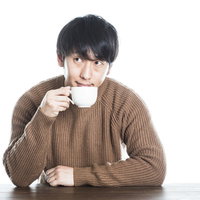 コーヒーカップを持つ男性の写真
