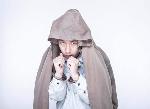 護送中の容疑者、手錠をかけられた男性の逮捕の写真