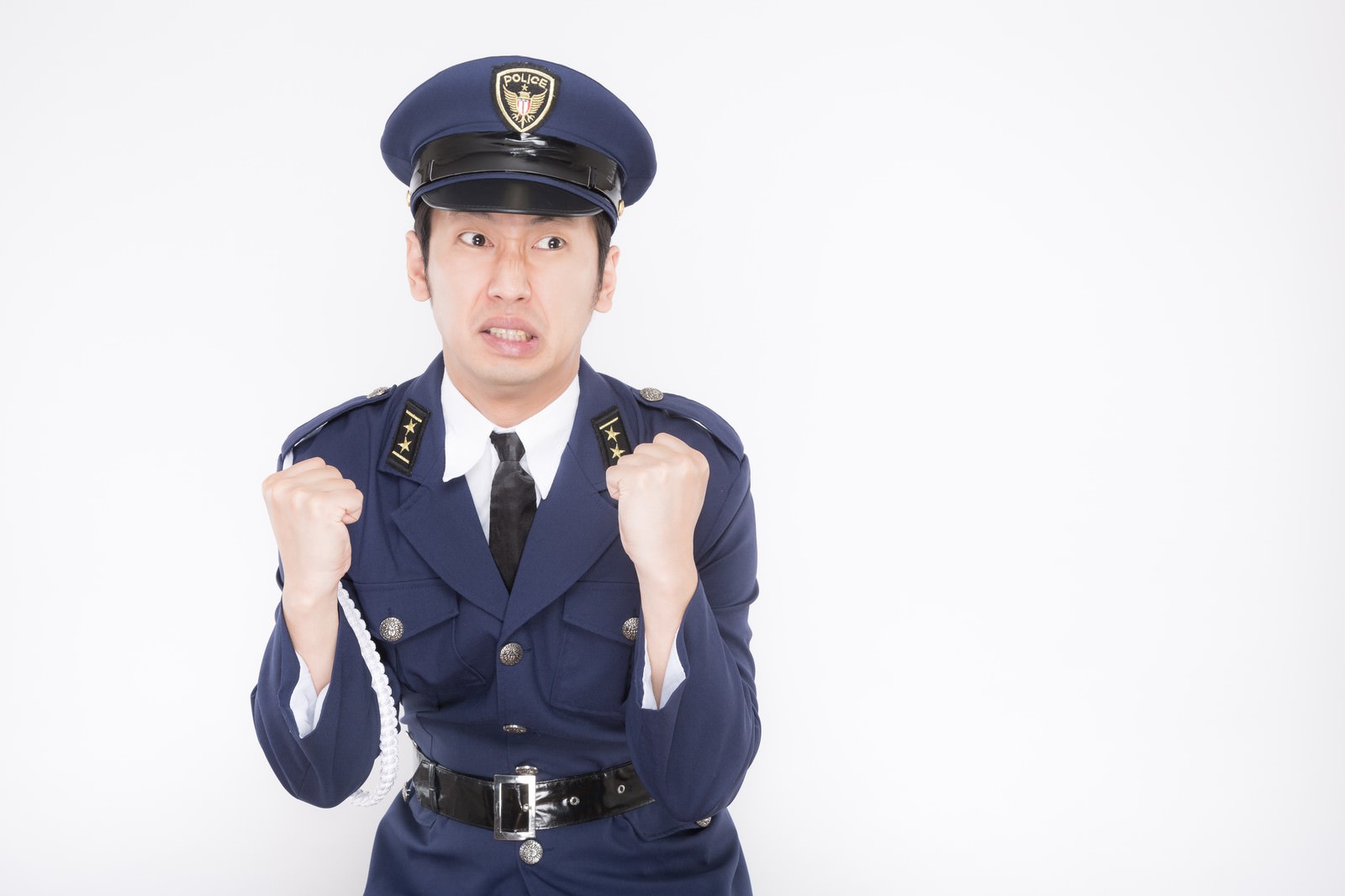 紺色の警察制服を着た新米警官の男性が両拳を握り張り出すポーズをしている［モデル：大川竜弥］