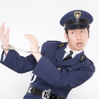 手錠をかけられたポーズをとるコスプレイヤー警官の写真