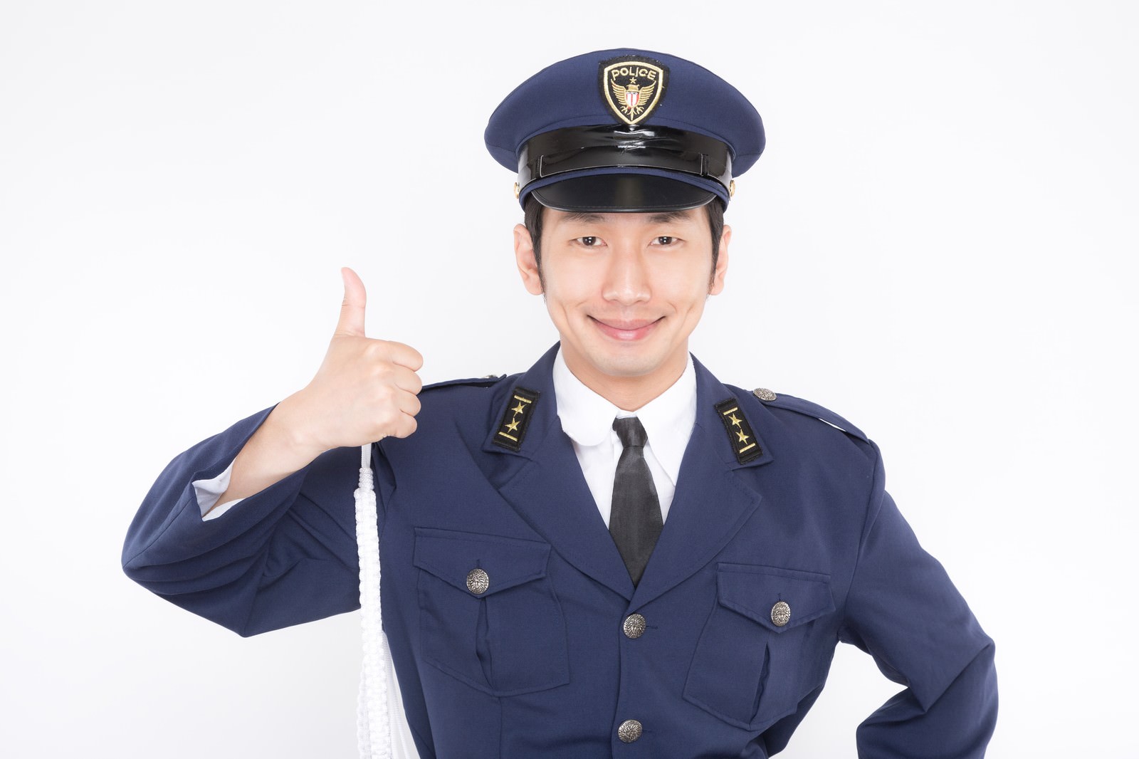 紺色の制服姿で親指を立てる男性警察官が笑顔でポーズをとっている［モデル：大川竜弥］