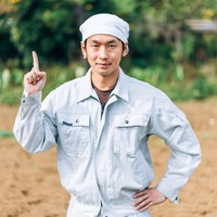 農家からのワンポイントアドバイス、白い作業着で指をさす男性の写真