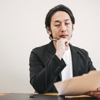 書類を選考する面接官の男性が真摯に検討している様子の写真