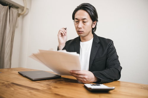 書類に目を通す面接官の男性、採用選考の審査の場面