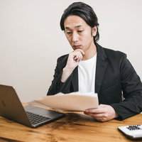「ほうほう」顎に手を添えて資料を見る男性の写真