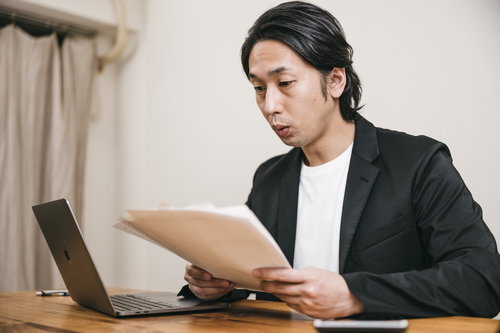 口をすぼめて書類を確認する男性採用担当者