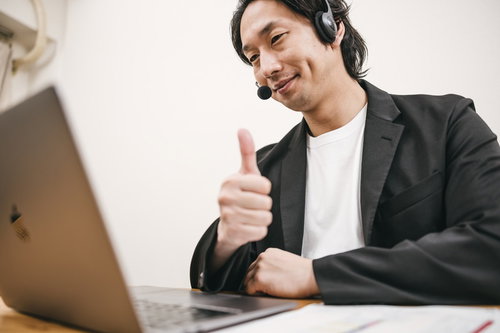 ヘッドセットを着用してグッジョブのポーズを取る男性