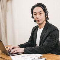 真剣なまなざしでパソコン作業に取り組むテレワーク中の男性の写真