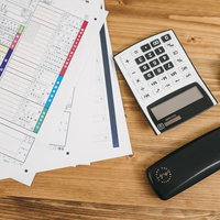 テーブル上の確定申告書類と電卓の写真