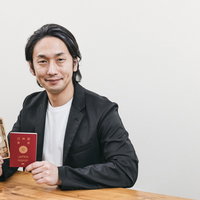 パスポートと一万円札を手に取るスーツ姿の男性の写真