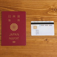 木目のテーブルに並ぶ旅券と個人番号カードの写真