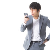 チャット相手がサクラだったことに気づくスーツ姿の男性の写真