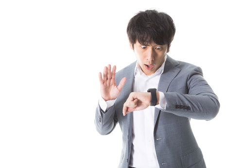 待ち合わせ時間を間違えたスマートウォッチを見て驚く営業マン